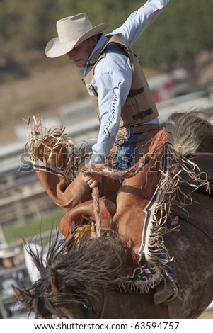 stock-photo-san-dimas-ca-october-unidentified-cowboy-competes-in-the-saddle-bronc-event-at-the-san-dimas-63594757.jpg